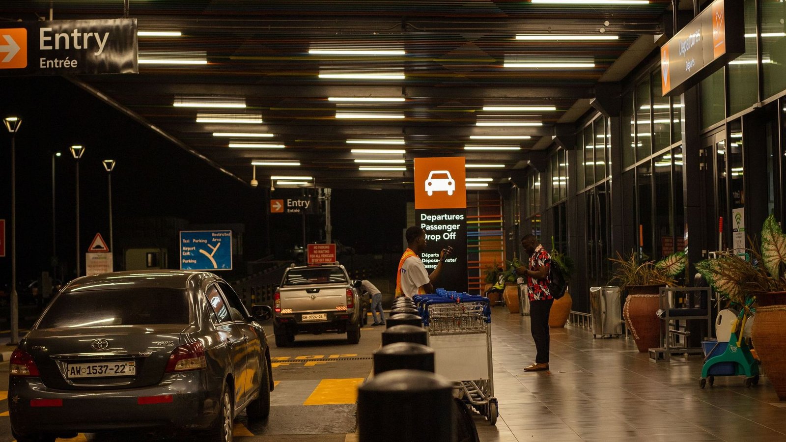 Cars waiting at an airport drop-off zone at night
