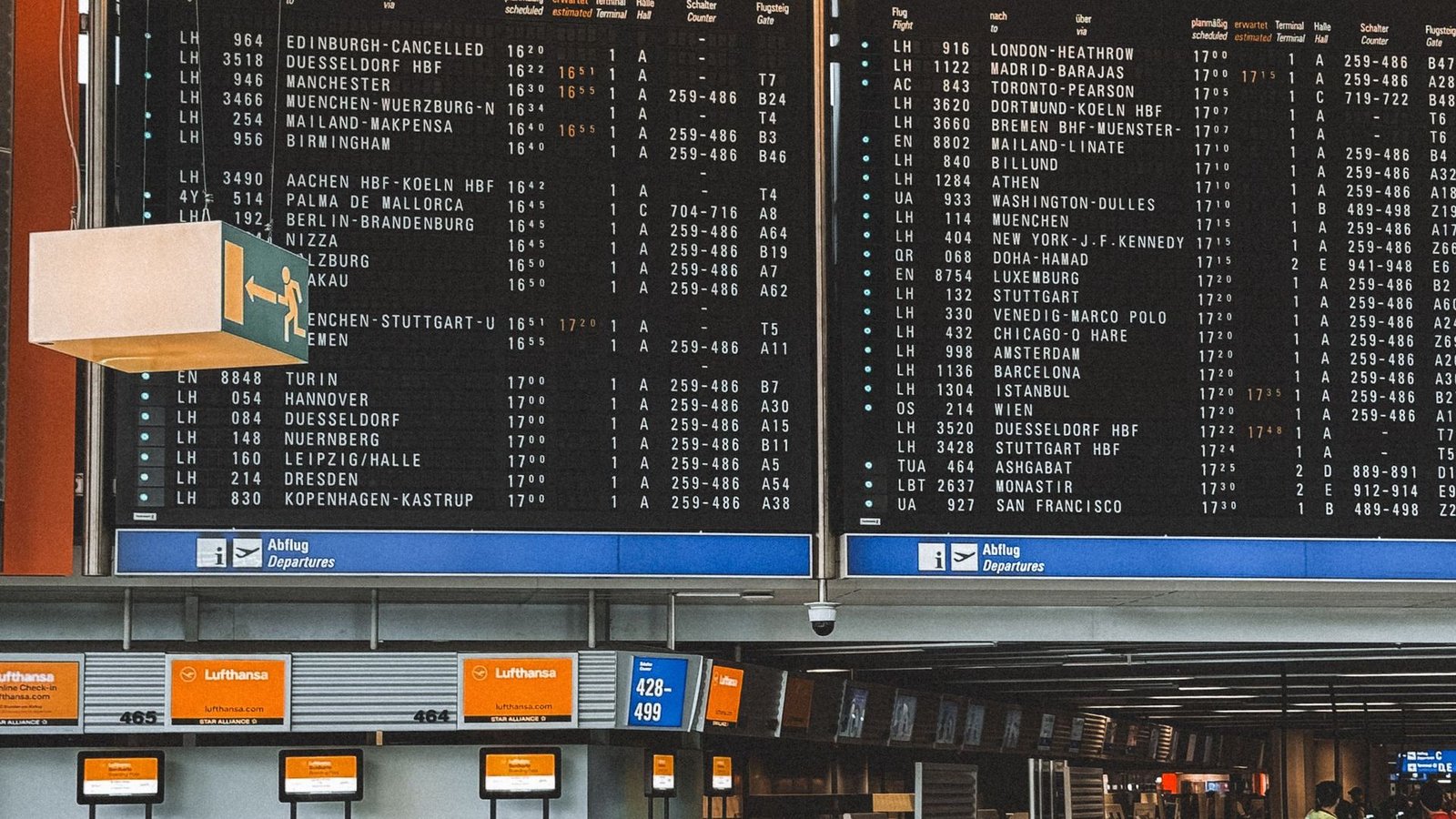 A departures board above the check-in desks