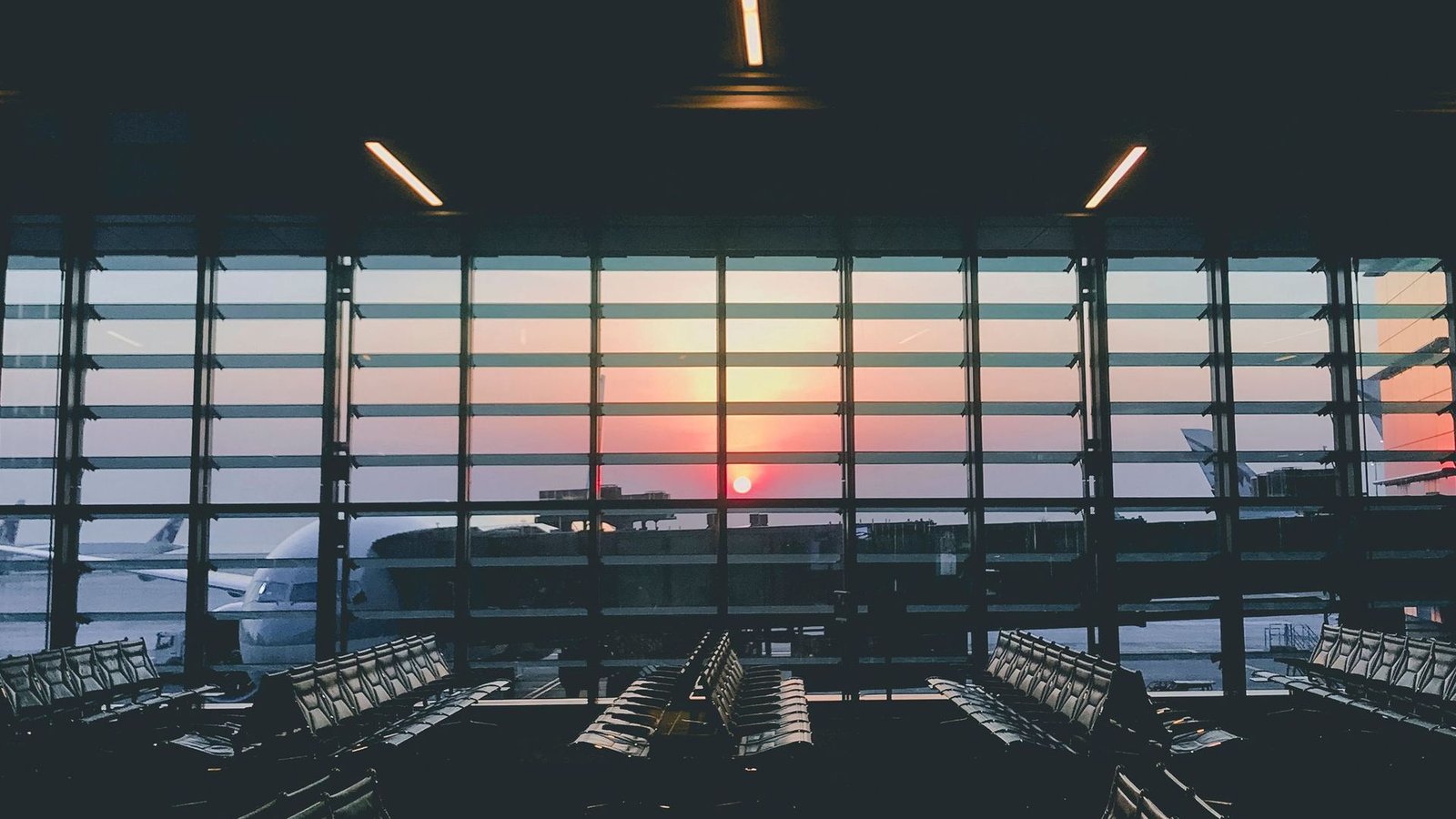 An airport terminal at sunset looking out over the aircraft stands