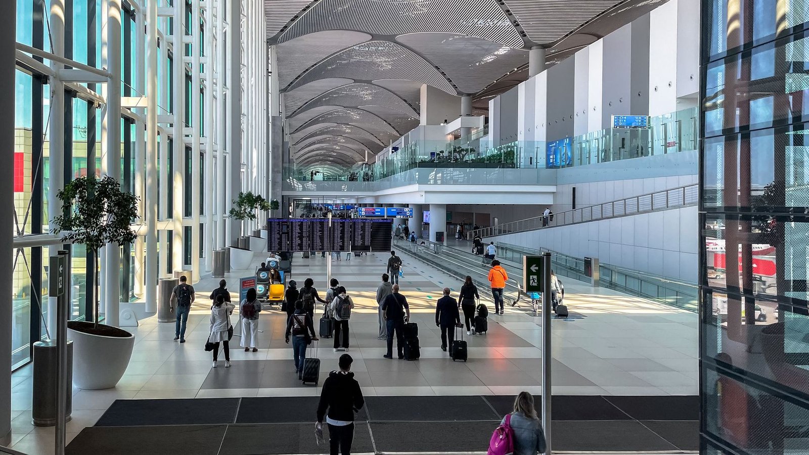 Travellers crossing a modern airport terminal